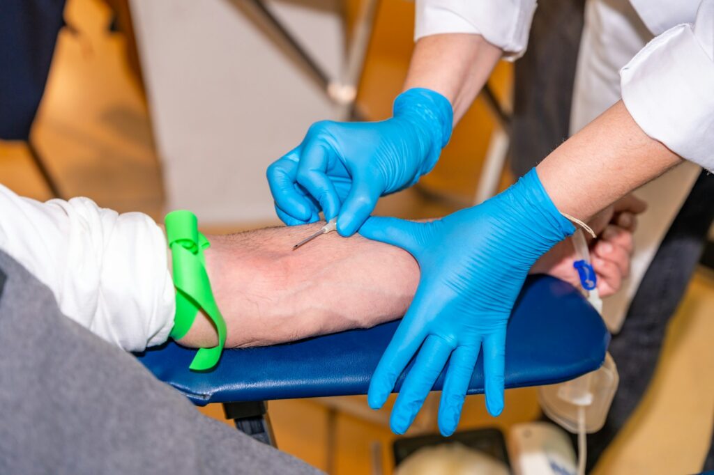 Nurse puncturing the vein of a blood donor